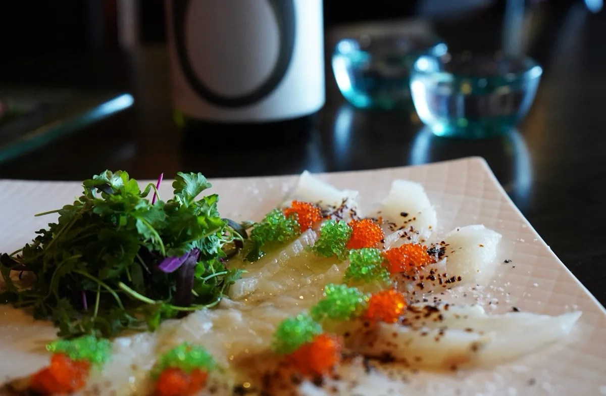 Thinly sliced white fish carpaccio topped with orange and wasabi tobiko, cracked pepper and fresh herbs